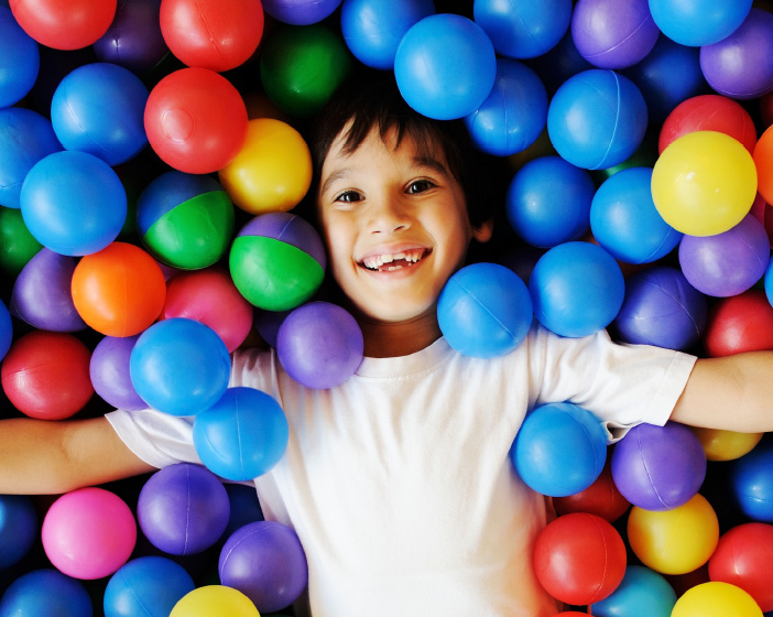 Boy jumping into ball pit